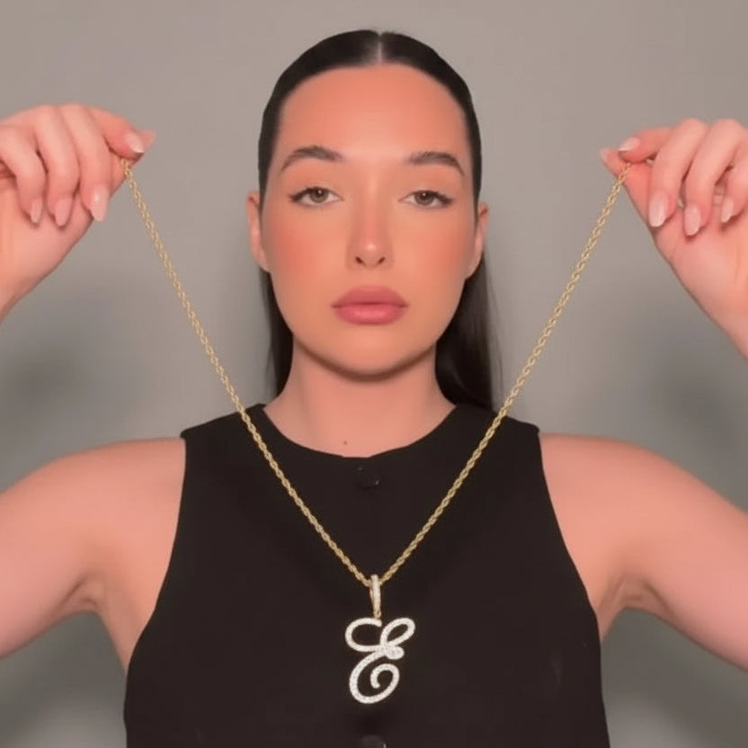 Woman wearing a gold necklace with a &