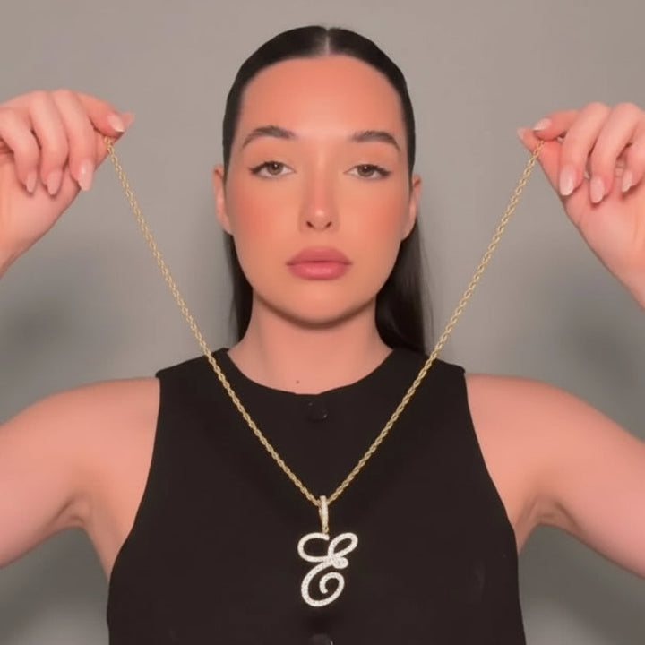 Woman wearing a gold necklace with a &
