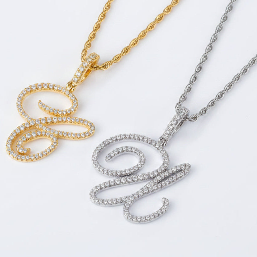 Gold and silver 'w' pendants on chains against a white background